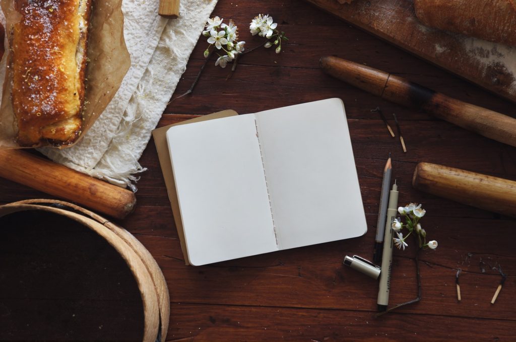 Diario en blanco encima de una mesa rústica